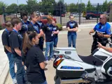 Traffic Officer showing his motorcycle to kids in the Youth Safety Academy.